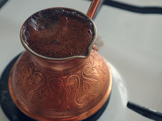 coffee is brewed in a copper Turk on the gas stove