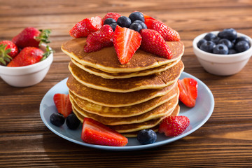 Tasty pancakes with blueberry and strawberry