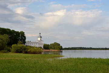 Fototapeta na wymiar Church of St. Michael the Archangel in the Yurievsky Monastery Veliky Novgorod. Beautiful summer view with a river and a church and a cloudy sky