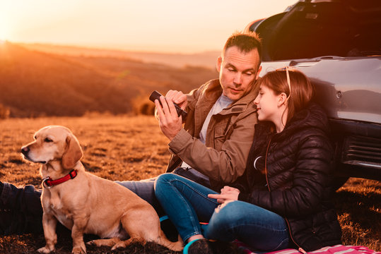 Father Teaching Daughter How To Use Binoculars At Camping