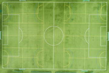 Aerial view from below on a large green football field with white and yellow lined lines. Texture of a football field. Copyspace