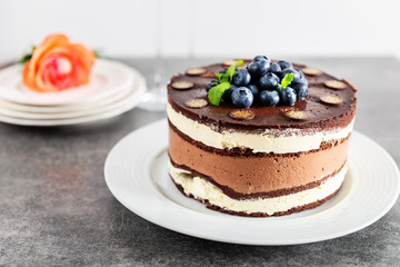 Belgian Chocolate Layered Gateau. Layers of moist choco sponge, vanilla cream and indulgent dark chocolate mousse glazed with rich dark chocolate sauce and hand decorated with fresh blueberries