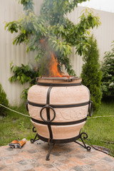 tandyr oven close up photo on the summer outdoor green garden background 