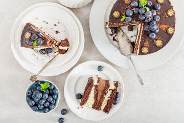 Belgian Chocolate Layered Gateau. Layers of moist choco sponge, vanilla cream and indulgent dark chocolate mousse glazed with rich dark chocolate sauce and hand decorated with fresh blueberries