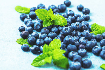 Fresh Blueberries on blue background, top view. Juicy wild forest berries, bilberries. Healthy eating or nutrition