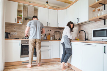 couple cooking on kitchen washing dishes