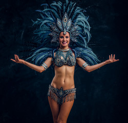 Happy brasil dancer is posing for photographer. She is wearing blue feather costume.