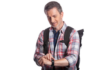 Middle-aged man or senior citizen checking heart rate pulse with health apps on a smartwatch. He also looks like a hiker checking the wearable technology for gps navigation.