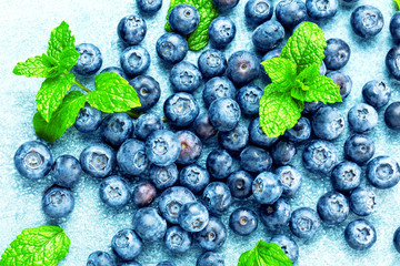 Fresh Blueberries on blue background, top view. Juicy wild forest berries, bilberries. Healthy eating or nutrition