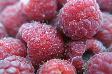 Raspberry berries in water drops macro photo as background.