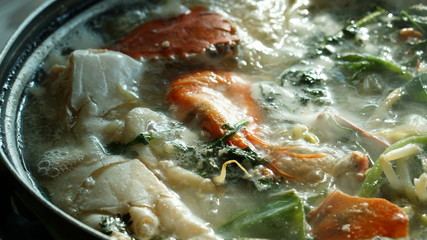 Obraz na płótnie Canvas Boiling seafood soup with shrimps, crabs, clams and vegetables cooked in Jagalchi fish market in South Korea in Busan.