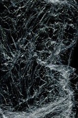 Transparent plastic wrap on the black background. Plastic bag texture. Reusable trash and waste.