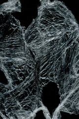 Transparent plastic wrap on the black background. Plastic bag texture. Reusable trash and waste.