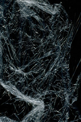 Transparent plastic wrap on the black background. Plastic bag texture. Reusable trash and waste.