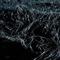 Transparent plastic wrap on the black background. Plastic bag texture. Reusable trash and waste.