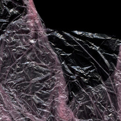Transparent plastic wrap on the black background. Plastic bag texture. Reusable trash and waste.