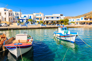 Fishing boats in picturesque Finiki port with colorful tavernas in background, Karpathos island,...