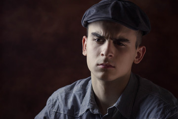 Close-up portrait of young man with beret hat thinking about something.