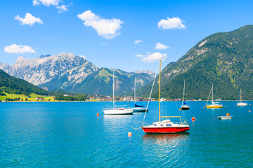 Fototapeta na wymiar Sailing boats and view of beach near Pertisau town at beautiful Achensee lake on sunny summer day, Tirol, Austria