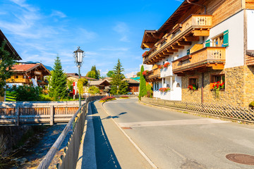 Naklejka premium Traditional alpine houses on street in village of Going am Wilden Kaiser on beautiful sunny summer day, Tirol, Austria