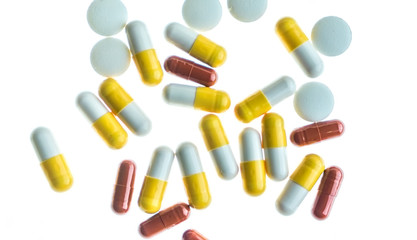 Pills and capsules against white back lit background