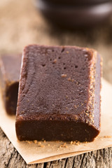 Panela oder Chancaca Vollrohrzucker am Stück (Selektiver Fokus, Fokus auf die vordere Oberkante des Zuckerstücks)