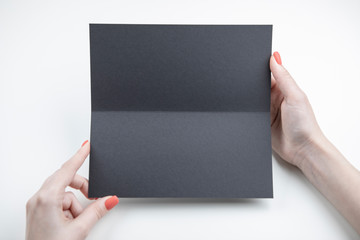 A woman holding black booklet