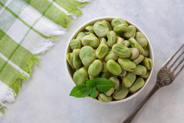 Boiled green beans on plate. Close up of boiled green beans on plate healthy and vegan dish with leaf of basil