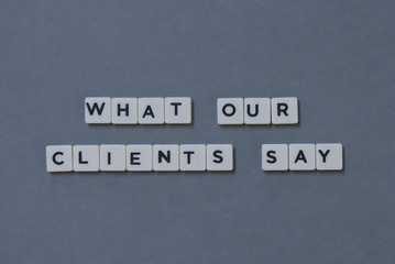' What Our Clients Say ' word made of square letter word on grey background.
