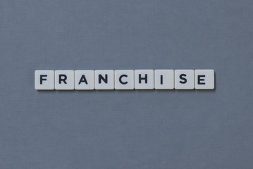 ' Franchise ' word made of square letter word on grey background.