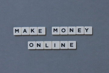 ' Make Money Online ' word made of square letter word on grey background.