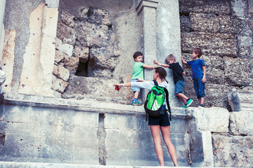 Fototapeta na wymiar mother with little sons on vacation visiting ancient colosseum, summer tourism, lifestyle people concept 