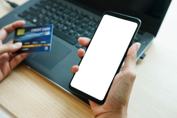 Asian young woman hands holding credit card and using laptop smartphone for online shopping concept