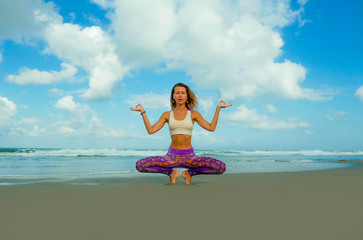 serenity and wellness . Young attractive and athletic woman in balance yoga posture at beautiful beach doing relaxation and meditation exercise happy and focused