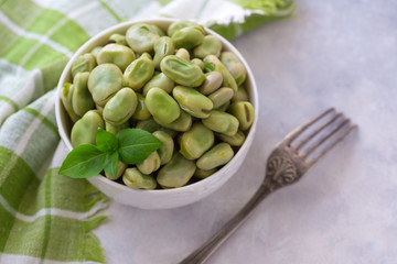 Boiled green beans on plate. Close up of boiled green beans on plate healthy and vegan dish with leaf of basil