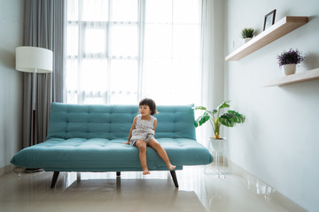 little girl sitting on a comfortable sofa in the family room