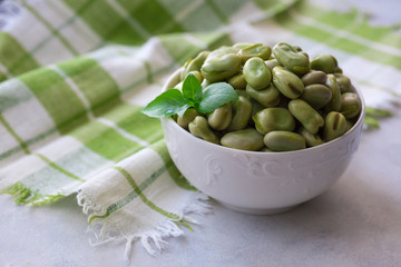 Boiled green beans on plate. Close up of boiled green beans on plate healthy and vegan dish with leaf of basil