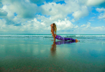 young happy and attractive fit and skinny blond woman doing yoga and relaxation exercise outdoors at beautiful beach in relax and meditation practice