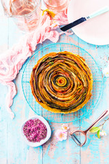 Spiral Gemüse Tarte auf bunt dekoriertem tisch.