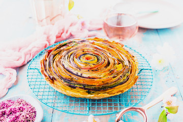 Spiral Gemüse Tarte auf bunt dekoriertem tisch.