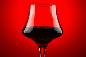 backlit cup of red wine close up horizontal composition