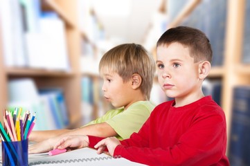 Two little boys studying subject on background