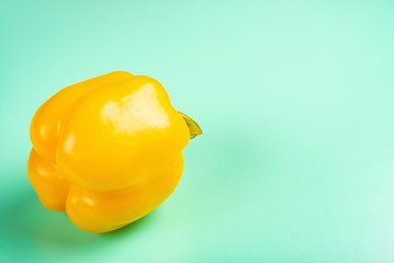 fresh yellow bell pepper on a light green background with copy space