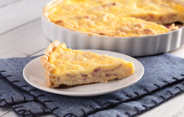 A Slice of Classic Quiche Lorraine on a Wooden Table