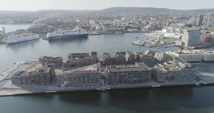 4K aerial with pan motion of the Oslo fjord, downtown Oslo and Bjoervika district, with the new Edvard Munch museum Lambda, Barcode quarter, Soerenga pier and Oslo Opera House.
