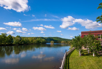 The Allegheny River in Warren, Pennsylvania, USA in springtime under bright blue skies with white clouds