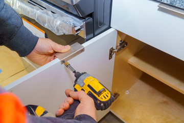 Hand on handle installation door in kitchen cabinet