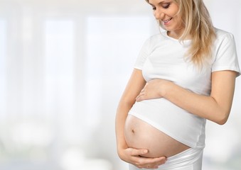 Pregnant young woman keeps the stomach