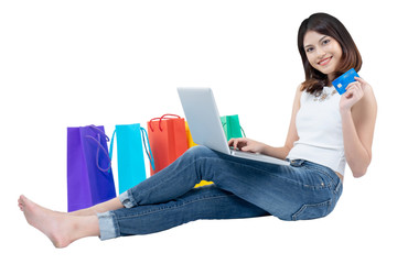 Happy woman in summer enjoying shopping with laptop holding credit card and colorful shopping bag on white background, shopping concept, isolate concept.