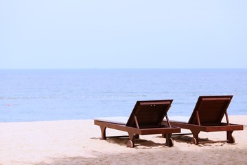 Fototapeta na wymiar Wooden day bed at the beach closeup summer ocean landscape background